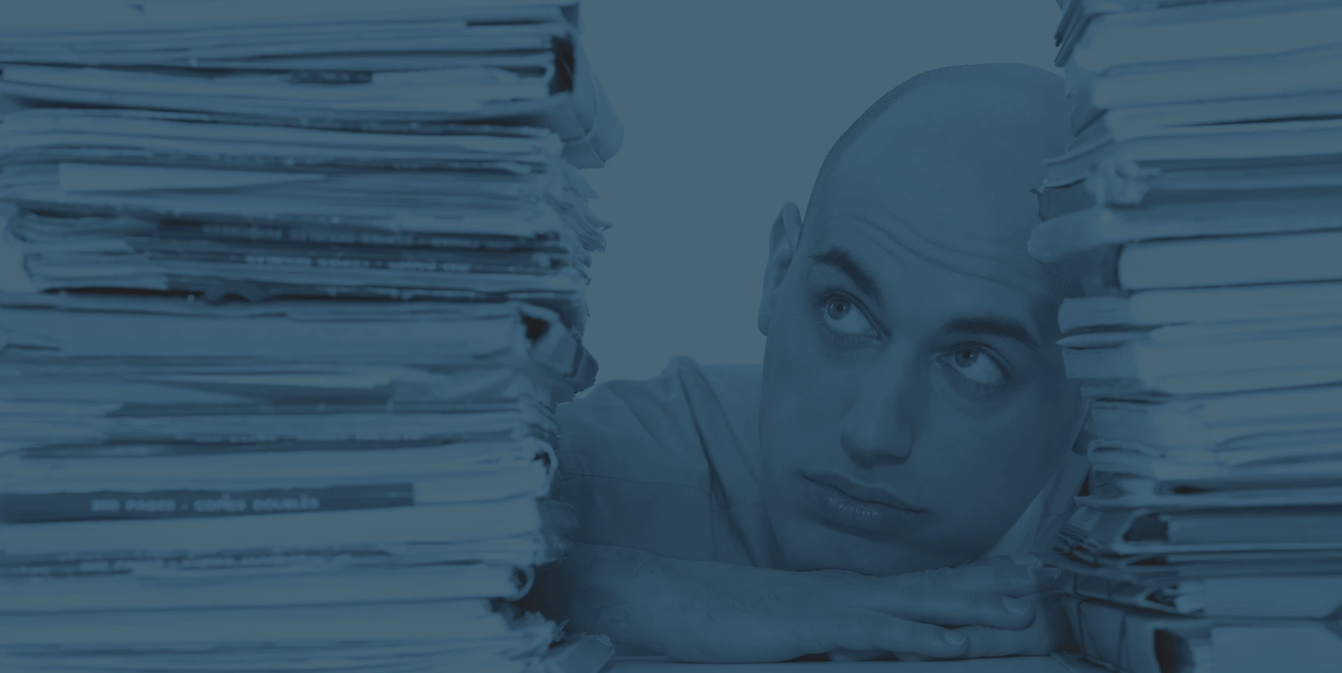 claims manager or administrator stressed leaning between stacks of claims files